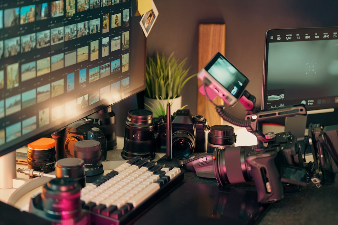 Desk with cameras, lenses, and computer screen. - Photo by Jakub Żerdzicki on Unsplash